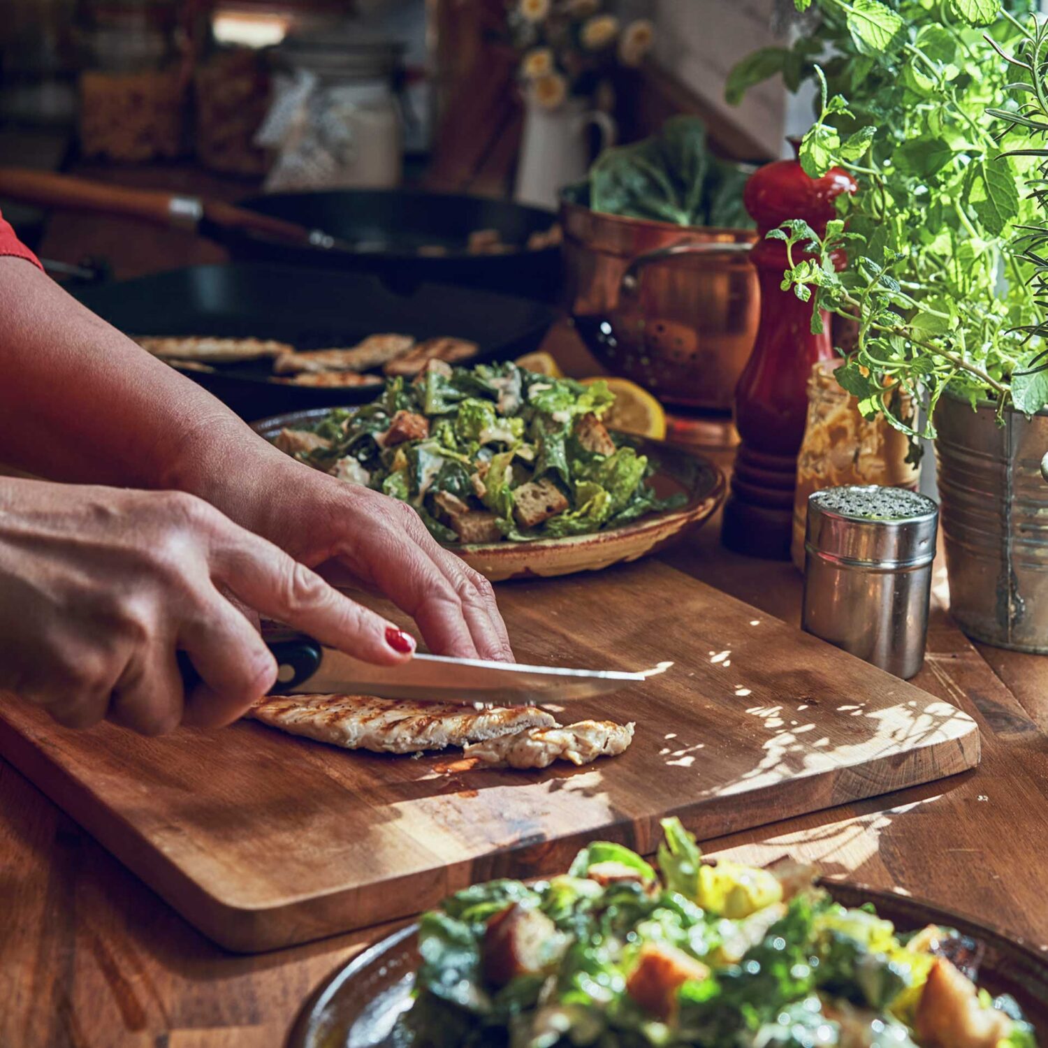 femme découpe du poulet sur une planche de bois