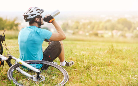 homme buvant sa gourde près de son vélo