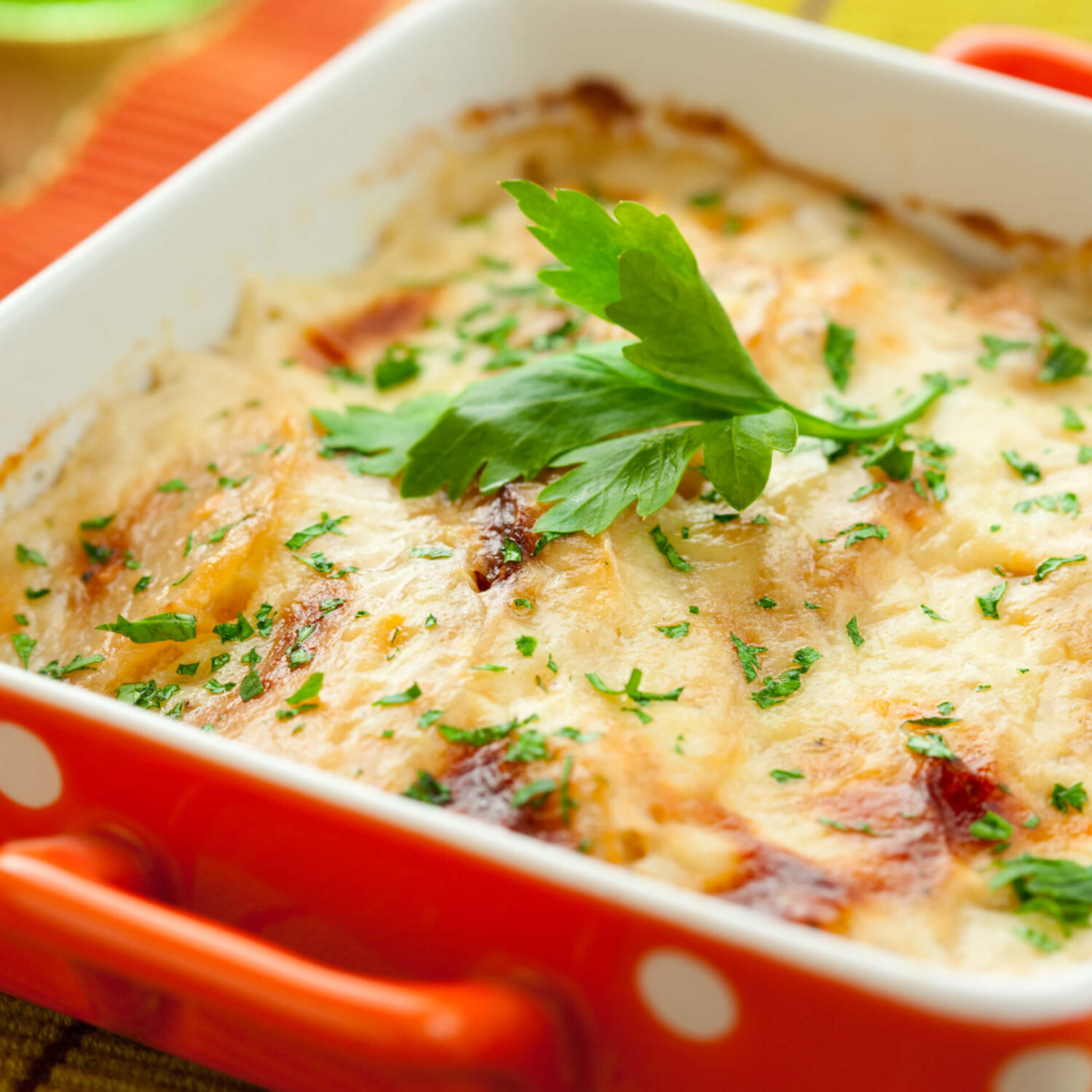 cassolette de légumes gratinée dans un plat rouge à pois blanc