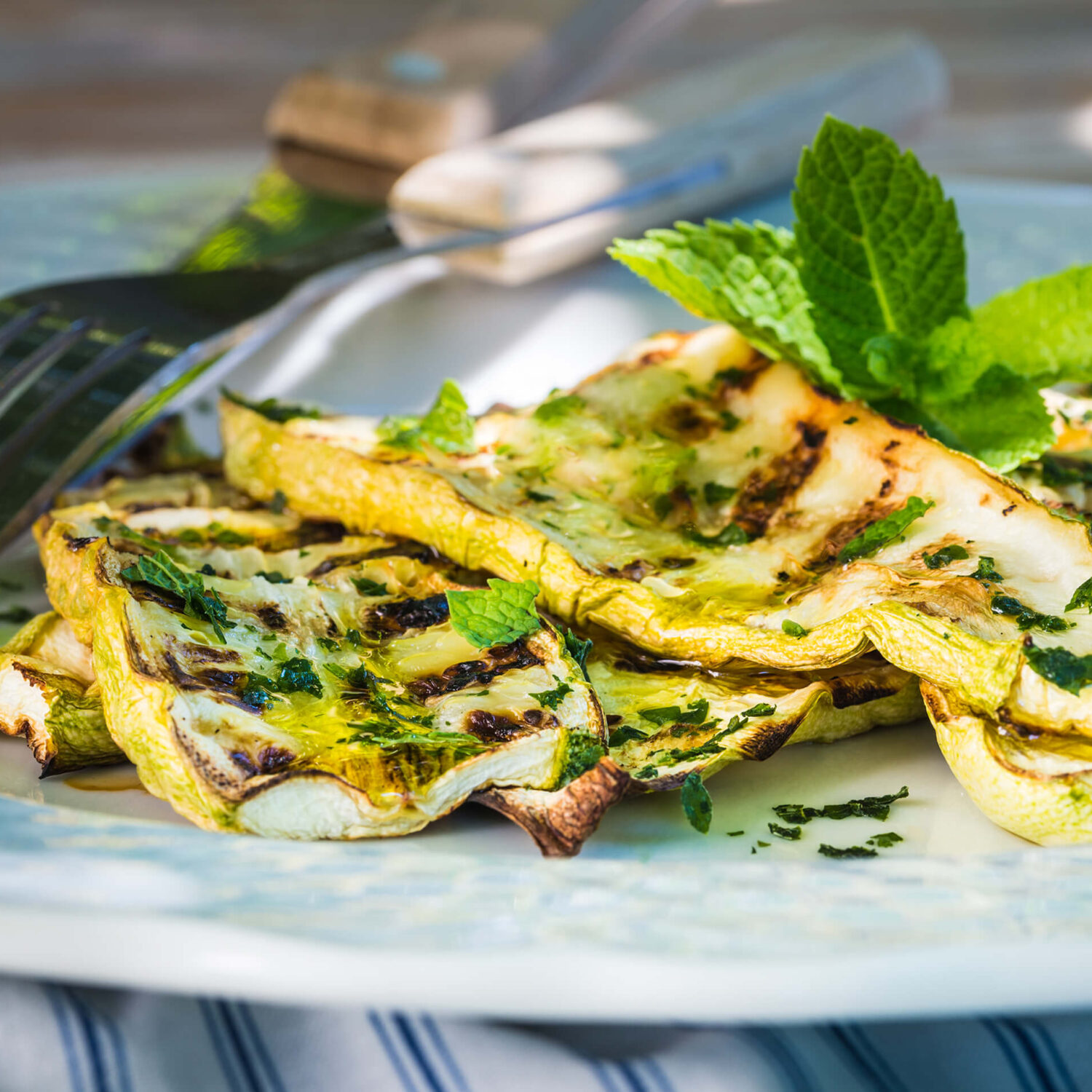 courgette grillées au parmesan sur une assiette avec couverts