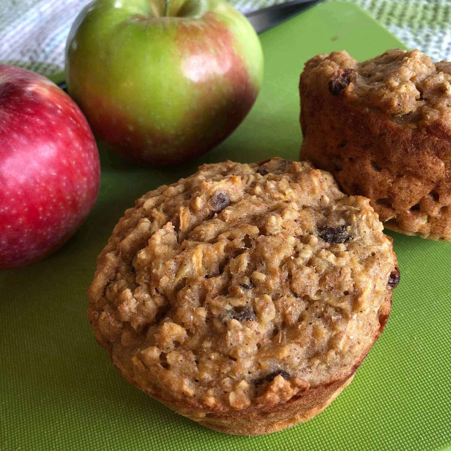 gros muffins aux pommes et aux épices sur une planche verte