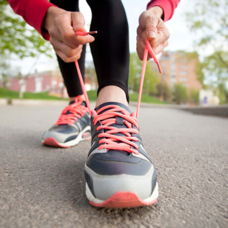 femme qui lasse ses chaussures de sport