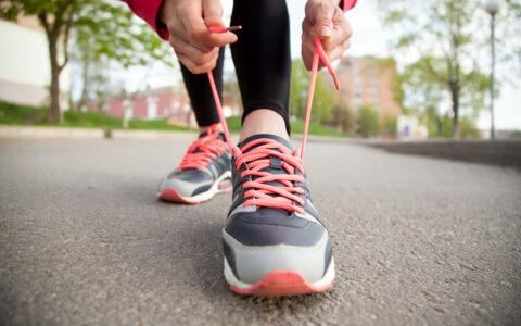 femme qui lasse ses chaussures de sport
