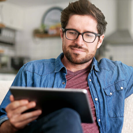 homme lisant sur sa tablette tactile