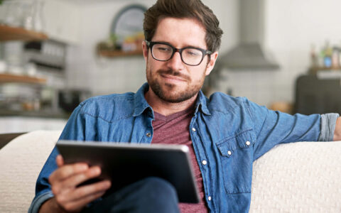 homme lisant sur sa tablette tactile