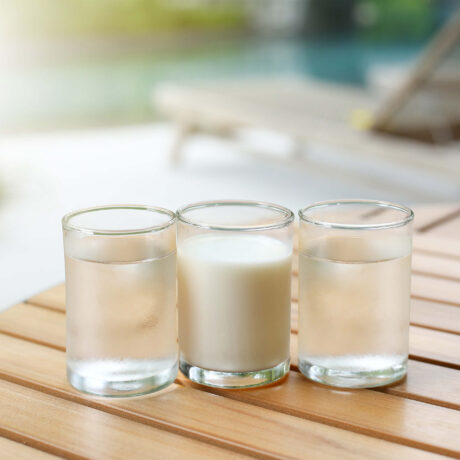un verre de lait et deux verres d'eau sur une table
