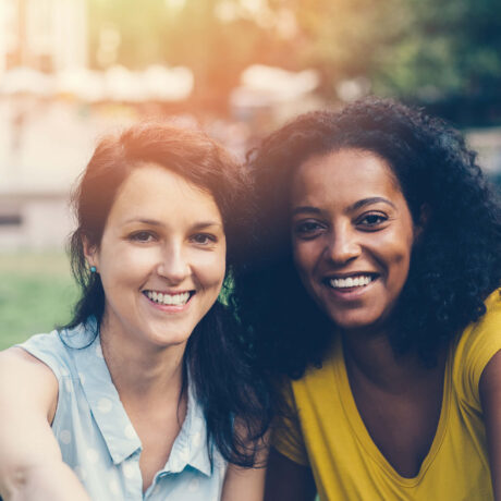femmes souriantes assisent dans un parc