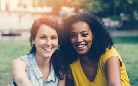 femmes souriantes assisent dans un parc