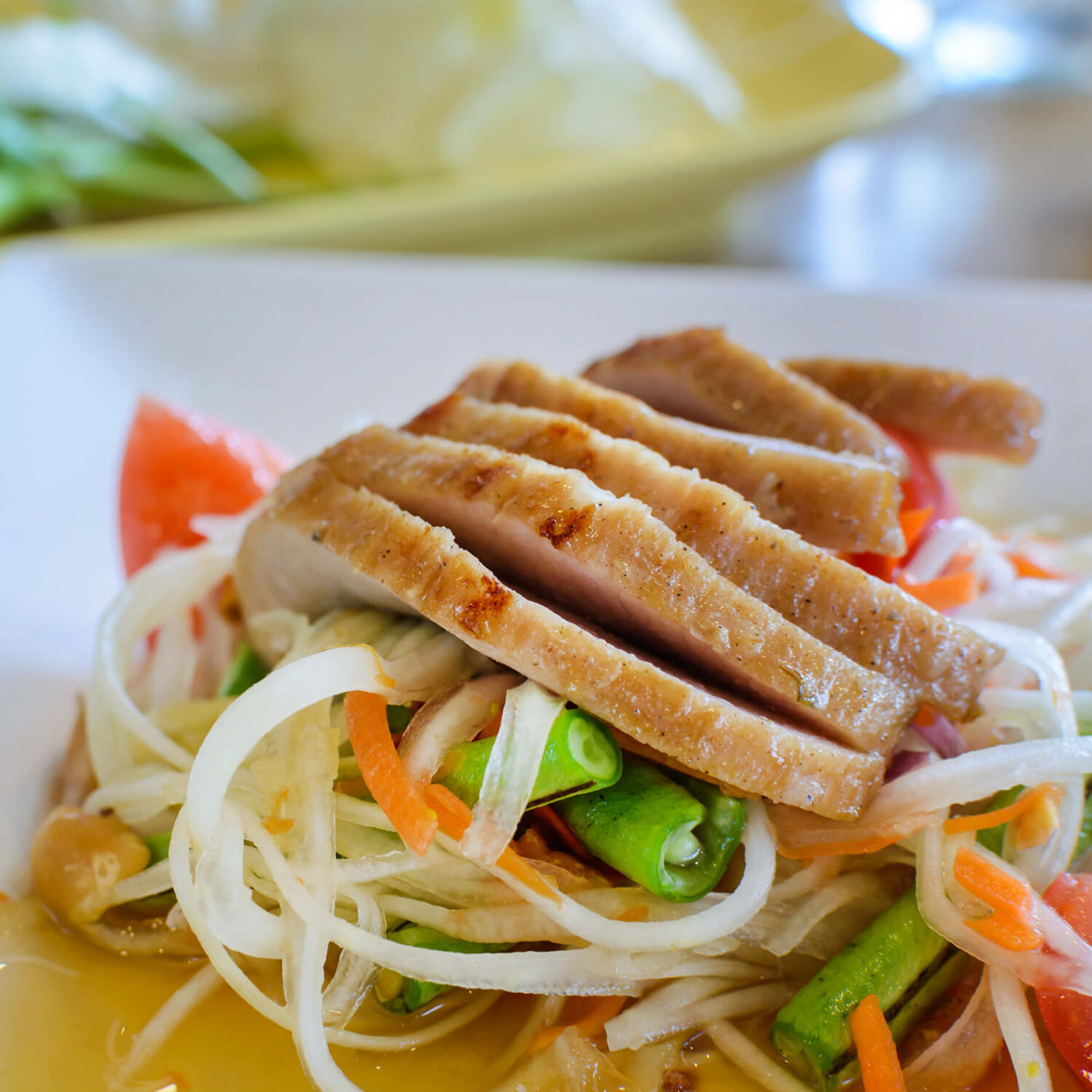 porc à l'orientale et petits légumes dans une assiette blanche