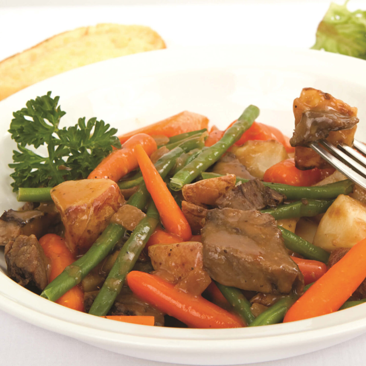 pot au feu viande et légumes dans assiette blanche