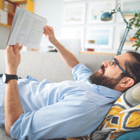 homme qui lit sur un canapé
