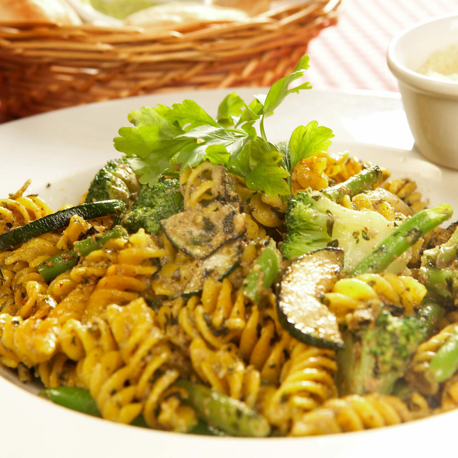 rotinis brocolis et courgette dans assiette et pot de parmesan
