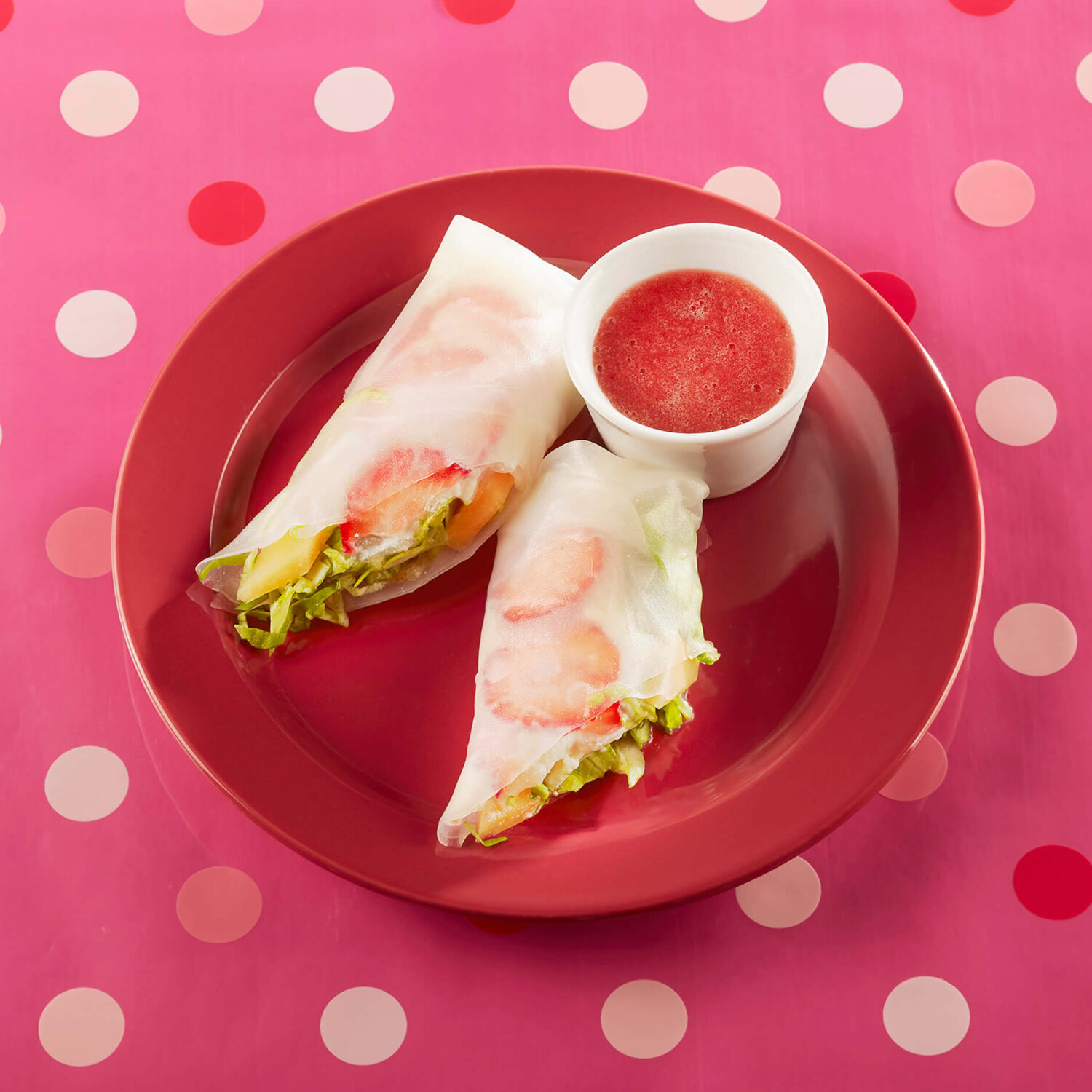 rouleaux de printemps au fruits et sauce fruits rouge dans assiette rouge