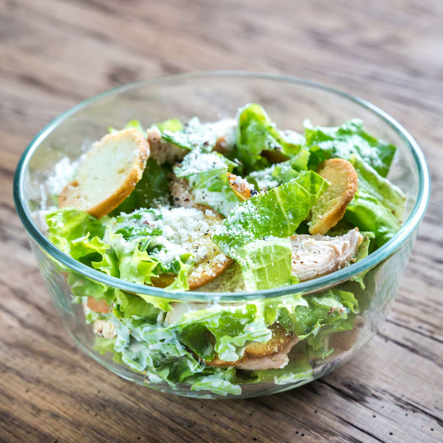 salade césar dans bol sur table en bois