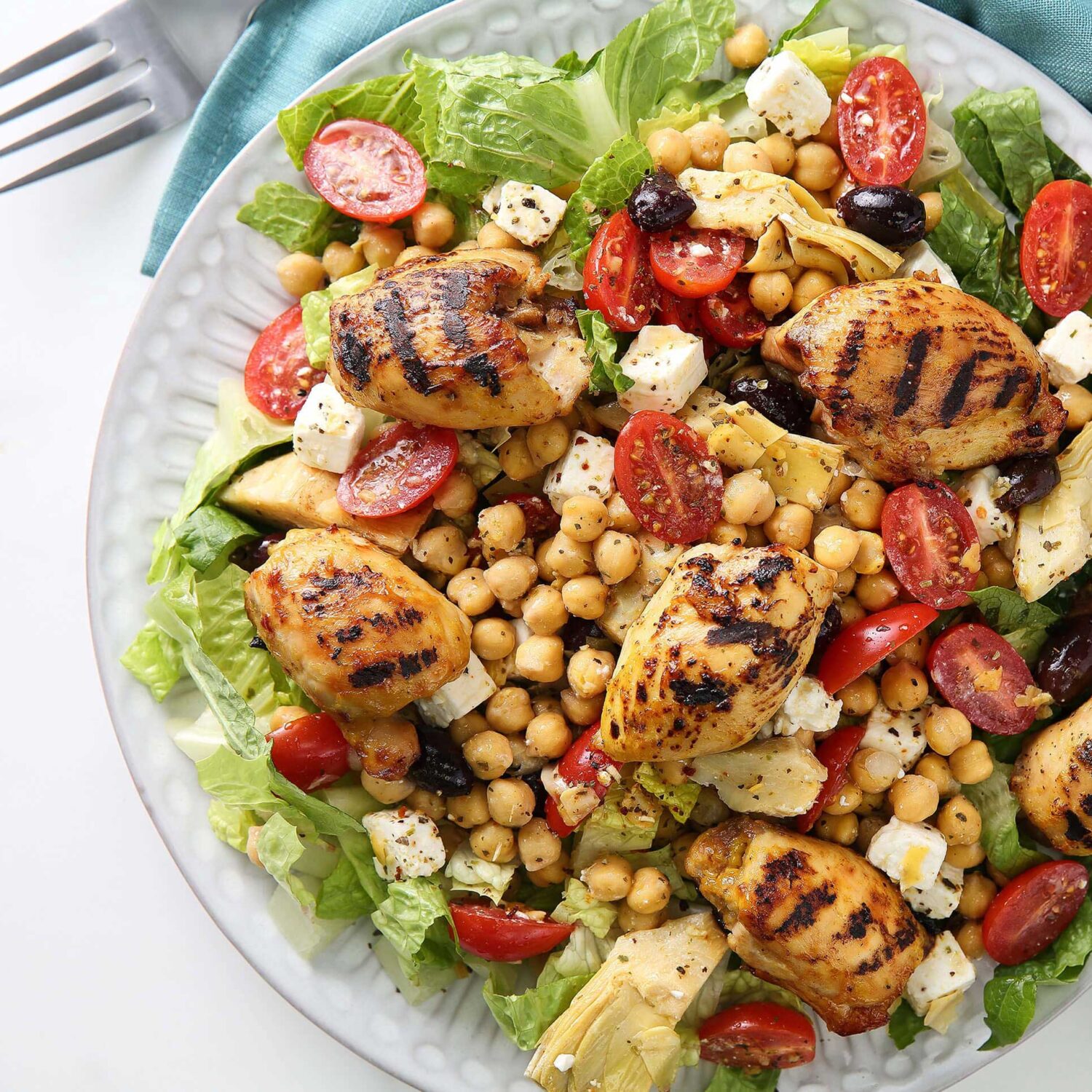 salade de poulet artichauts pois chiches et tomates dans assiette