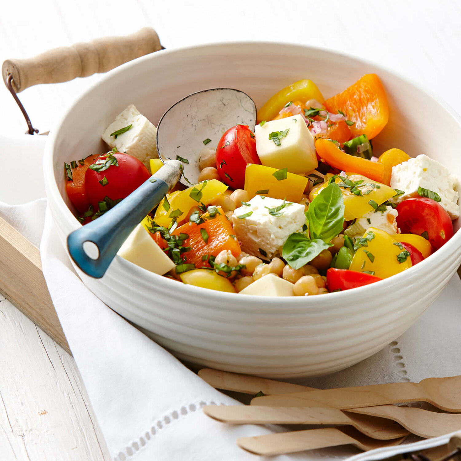 salade de tomates fromage et pois chiches sur plateau en bois