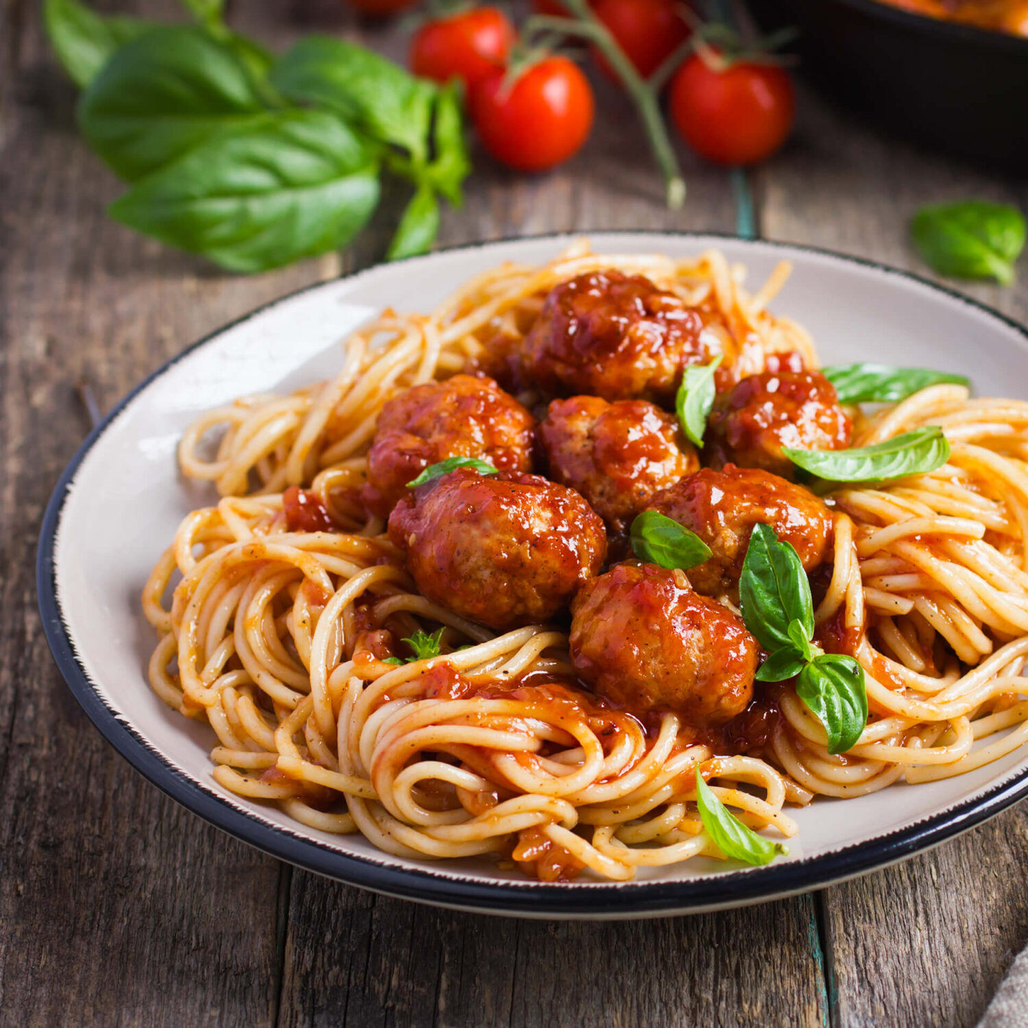 assiette de spaghetti et boulettes de dinde sur table en bois
