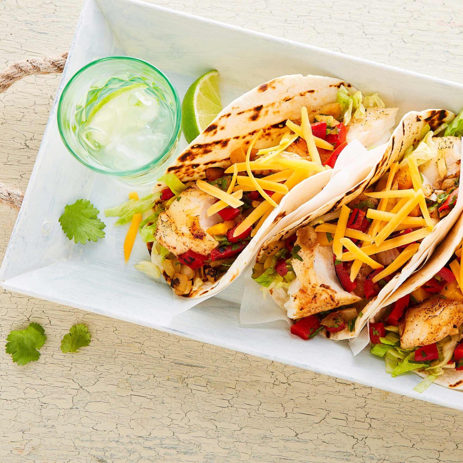 tacos de poisson et cheddar dans une assiette avec verre d'eau