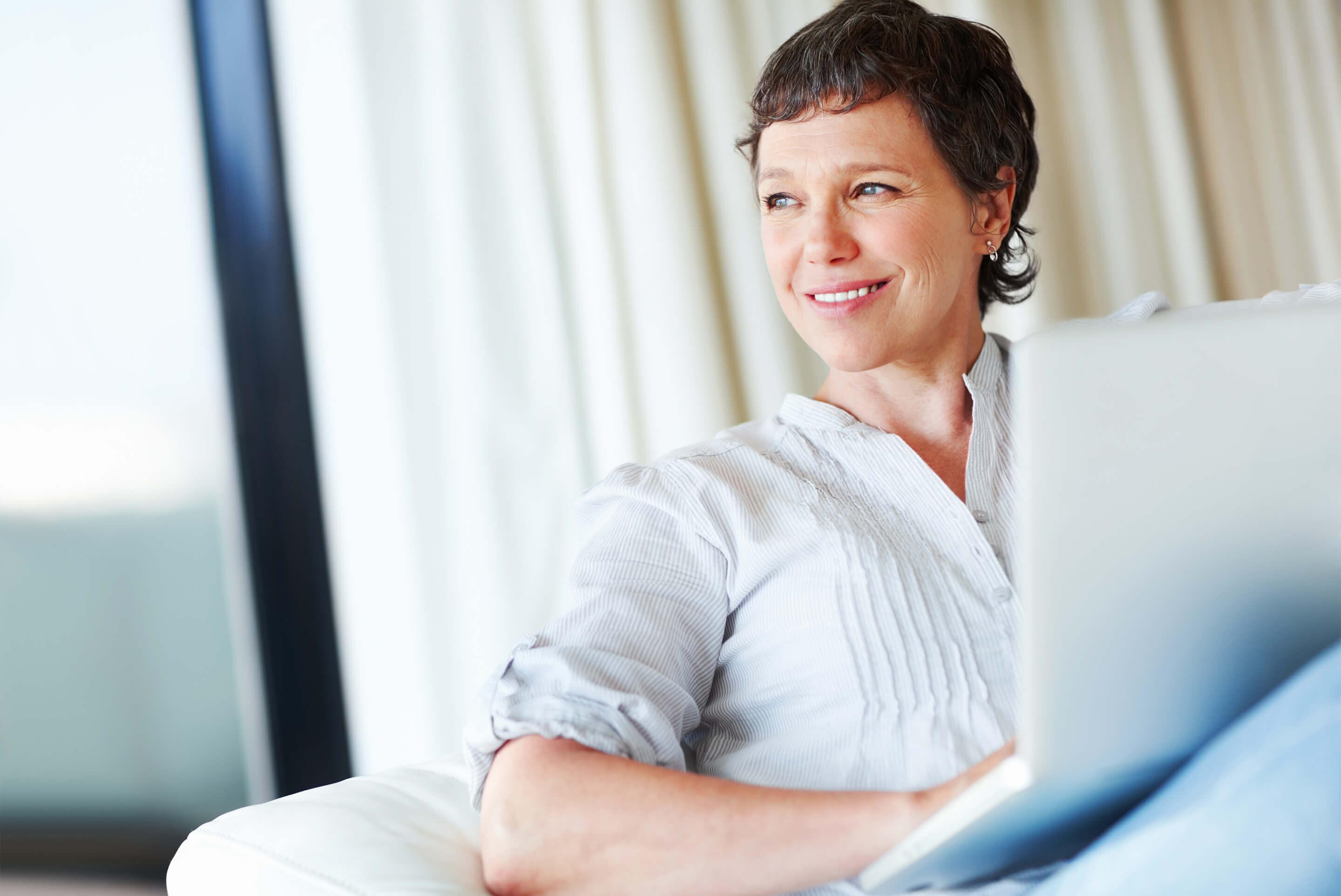 femme souriante qui travaille sur son ordinateur portable
