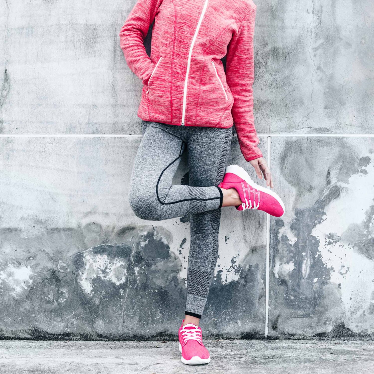 femme en tenue de sport contre un mur