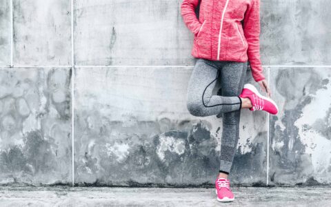 femme en tenue de sport contre un mur
