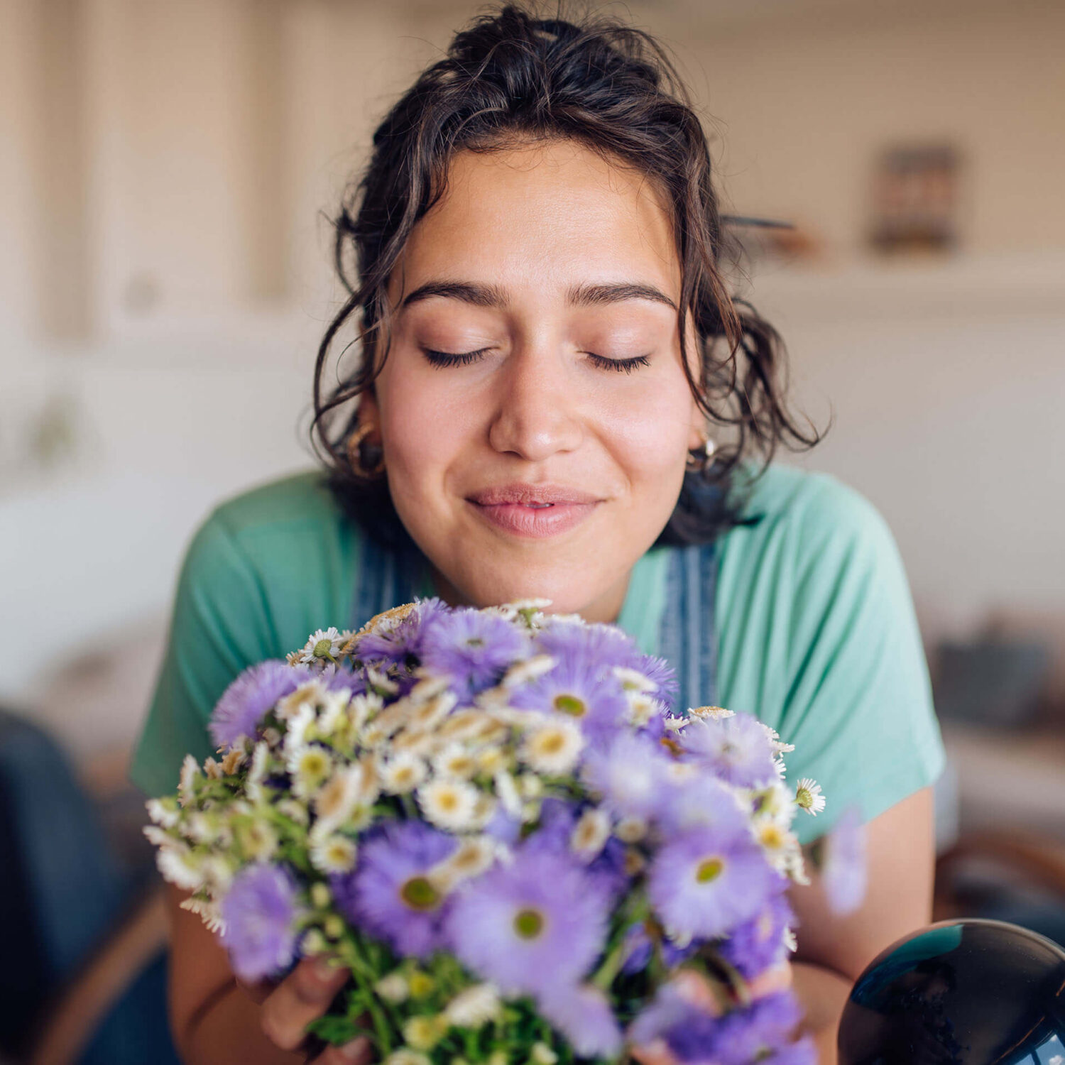 femme respirant un bouquet de fleurs