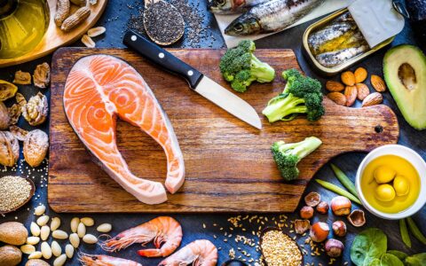 planche à découper avec tranche de saumon légumes et céréales