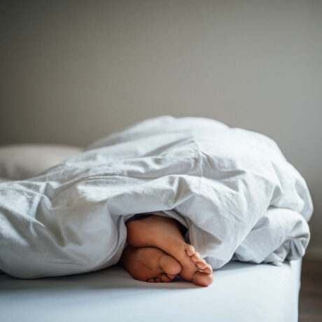 pieds qui dépassent sous une couette