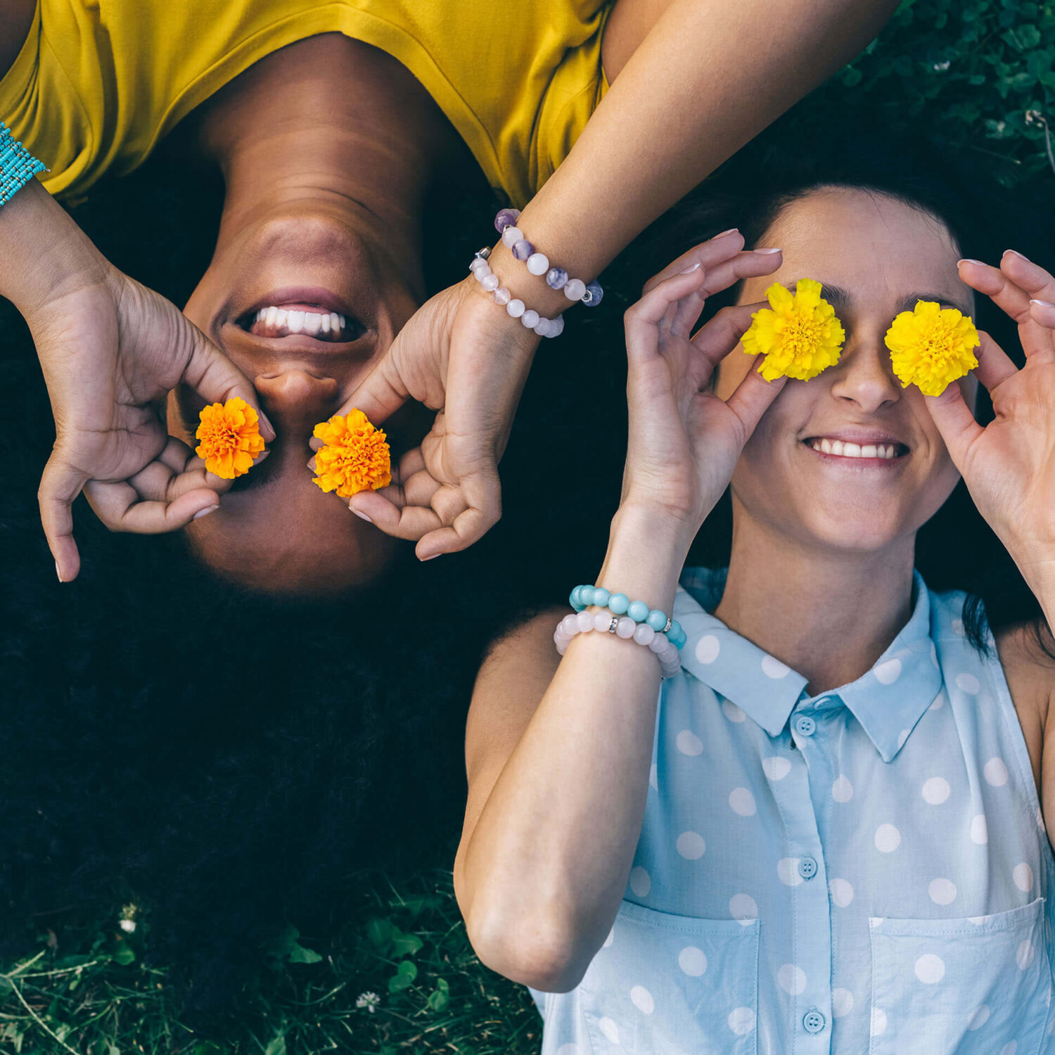 femmes dans l'herbe jouant avec des fleurs