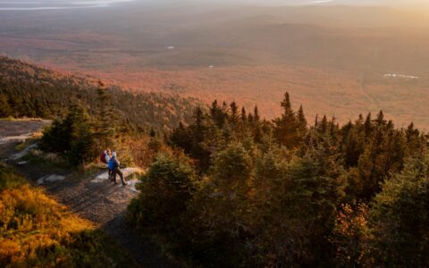 deux personnes au sommet d'une montagne l'automne