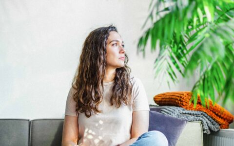 femme pensive assise sur un divan