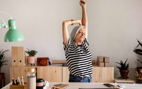 femme qui s'étire à son bureau