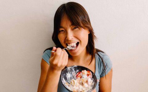 femme qui mange un bol de yogourt aux fruits